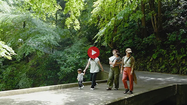 子供連れの親子が自然の中を歩いている