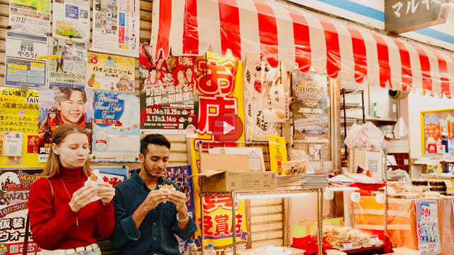 商店の前で食べるふたり